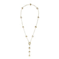Gold-plated lariat necklace with baroque pearls and textured caps on cream background, showing adjustable Y-shaped design.