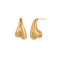 Organic sculptural gold stud earrings with fluid matte finish on cream background