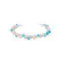 Delicate wire-wrapped bracelet featuring turquoise, rose quartz, freshwater pearls, and zircon on a white background.